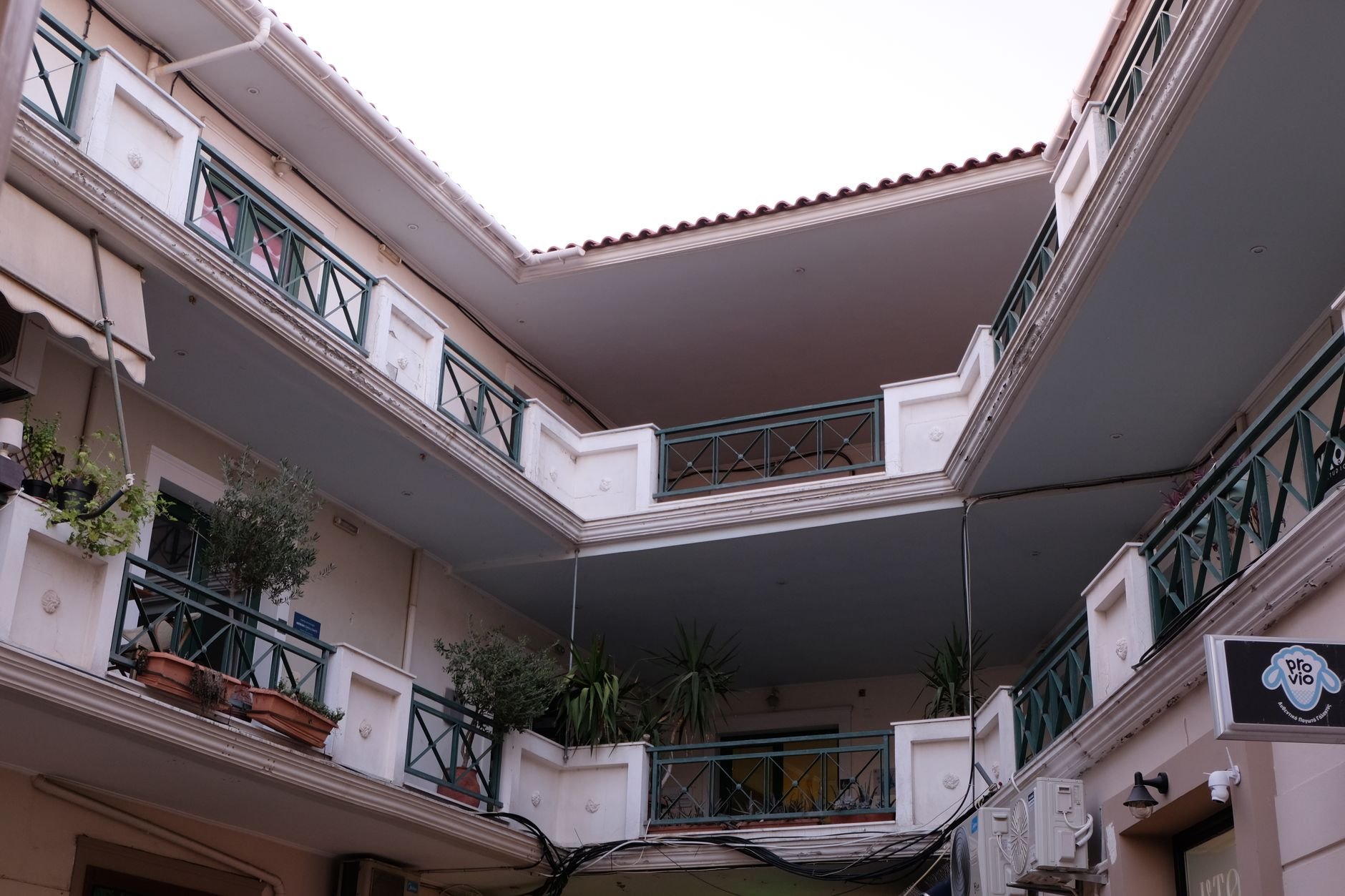 Stylish modern apartment building with balconies and plants, urban residential architecture